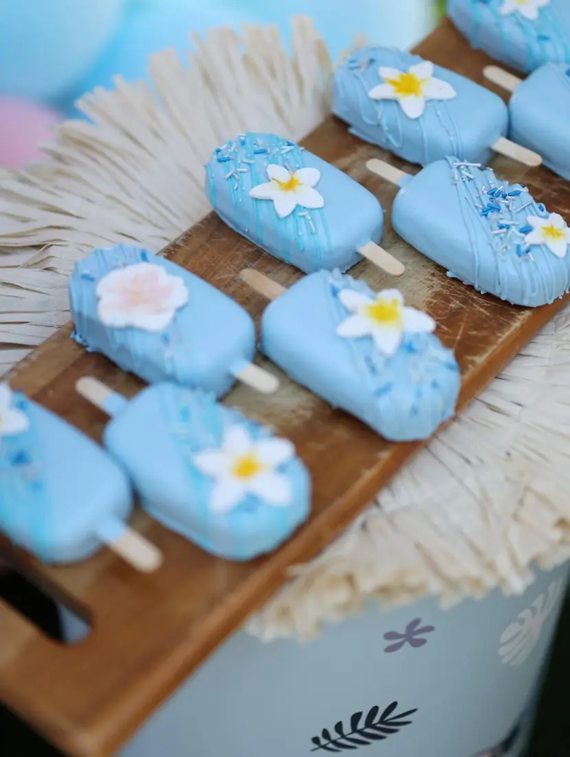 Baby blue cakesicles decorated with sugar flowers