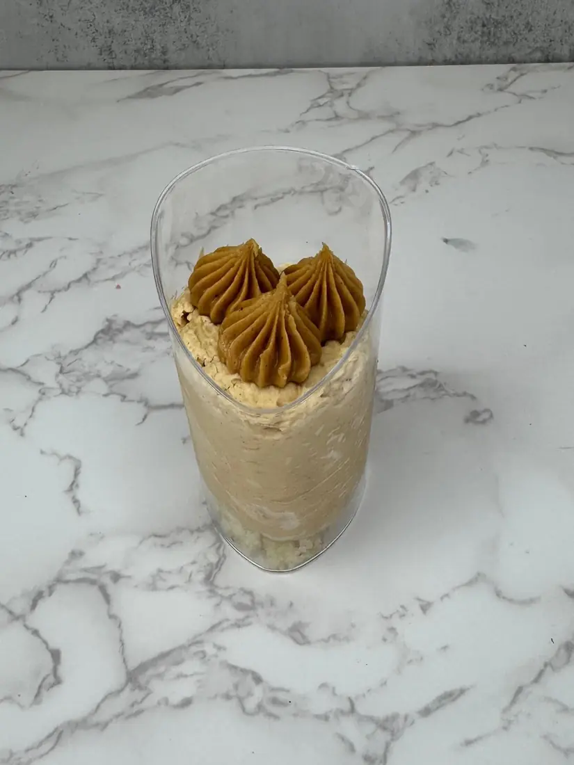 Individual caramel mousse dessert cup with piped topping