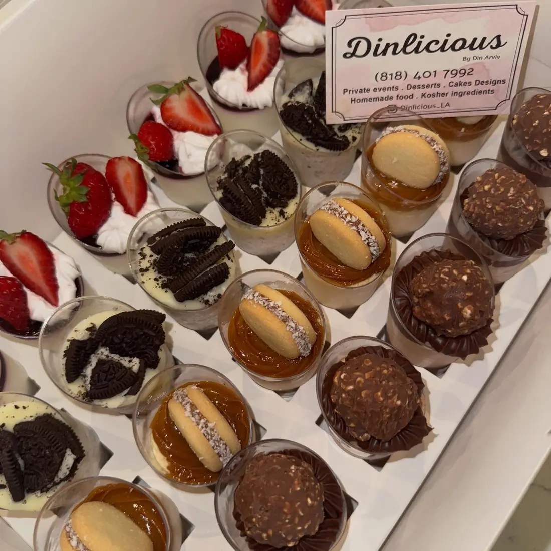 Assorted individual dessert cups with strawberries and cookies