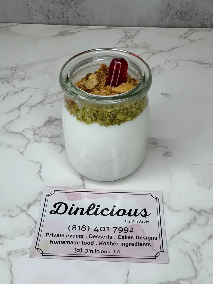 Malabi in a glass jar topped with pistachios and rose