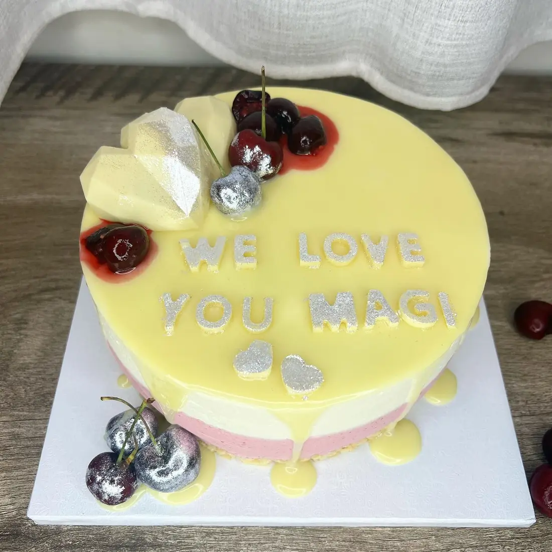 Cheesecake mousse cake with smooth yellow glaze, cherries and gold accents